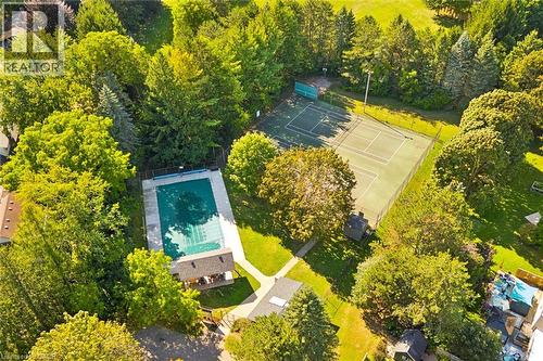 Expansive outdoor space featuring a covered swimming pool, tennis court, and lush mature trees - 351 Craigleith Drive, Waterloo, ON 