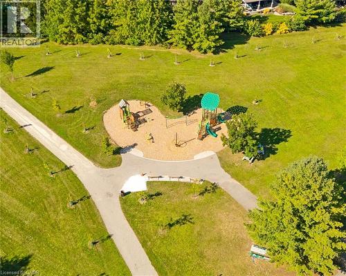 Expansive green space featuring a paved pathway, playground with equipment, and mature trees - 351 Craigleith Drive, Waterloo, ON 