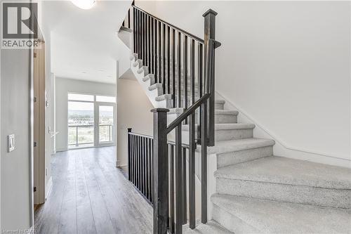 Staircase with carpeted treads and dark balusters - 58 Windward Drive, Grimsby, ON 