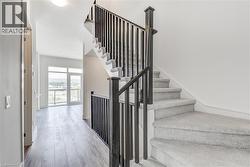 Staircase with carpeted treads and dark balusters - 
