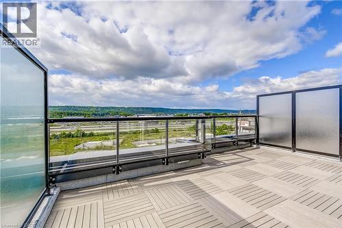 Expansive outdoor terrace featuring modular tile flooring, clear glass railings, and a partial privacy screen - 58 Windward Drive, Grimsby, ON 