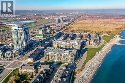 Waterfront community with a large residential tower, multiple mid-rise buildings with balconies, and a rocky shoreline - 58 Windward Drive, Grimsby, ON 