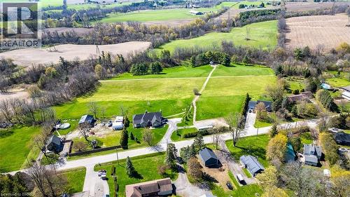 Expansive property featuring a large residence with a dark roof, multiple outbuildings, and extensive green space - 47 River Road, Brantford, ON 