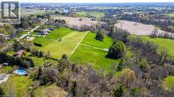 Expansive green landscape with defined grassy pathways, surrounded by mature trees and natural foliage - 