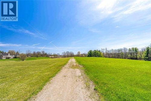 Expansive green lawn with a visible dirt path - 47 River Road, Brantford, ON 