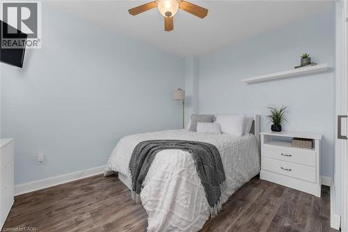 Bedroom featuring dark wood finished floors and a ceiling fan - 5 Viking Court Unit# 301, Grimsby, ON 