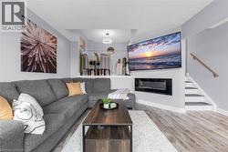 Living room with light wood-style flooring and a glass covered fireplace - 