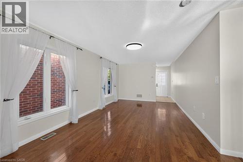 Hardwood flooring, painted walls, white trim, recessed lighting, and a front entry door - 103 Emick Drive, Ancaster, ON 