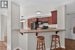 Kitchen with wood-finish cabinetry and black appliances - 