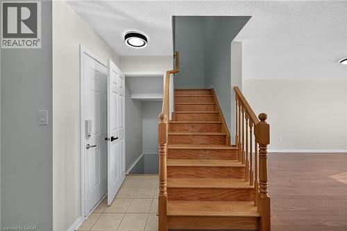 Wood-finish staircase with turned wood newel post and balusters - 103 Emick Drive, Ancaster, ON 