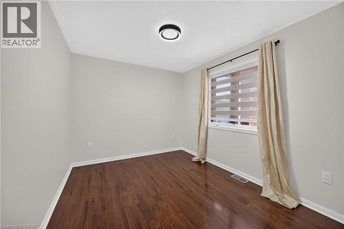 Wood-finish flooring, neutral wall tones, recessed window, and contemporary ceiling light fixture - 103 Emick Drive, Ancaster, ON 