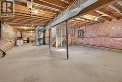 Unfinished basement featuring exposed wood joists, concrete flooring, and insulated walls - 