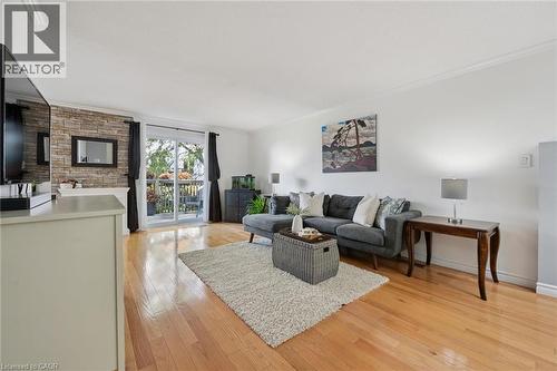 Hardwood flooring, white walls, crown molding, stone accent wall, sliding glass door to exterior - 54 Green Valley Drive Unit# 13, Kitchener, ON 