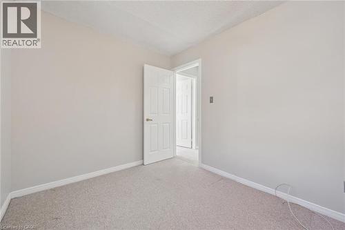 Light-colored carpeting, neutral wall paint, and a textured ceiling - 512 Thorndale Drive, Waterloo, ON 