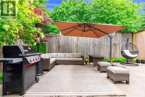 Concrete patio with a privacy fence and mature perimeter plantings - 2435 Coho Way, Oakville, ON 