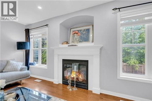 Hardwood-finish flooring, recessed lighting, white trim, gas fireplace with white mantel, and arched alcove - 2435 Coho Way, Oakville, ON 