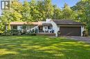 Expansive front lawn, mature trees, wood-finish front porch, attached garage with dark door, and white exterior siding - 282 Concession Rd 2, Scotland, ON 