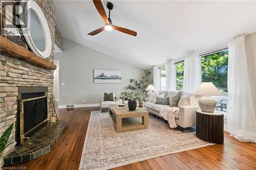 Vaulted ceiling, stone fireplace with hearth, wood-finish flooring, ceiling fan, and large windows - 282 Concession Rd 2, Scotland, ON 