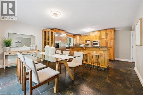 Kitchen with wood cabinetry, stainless steel refrigerator, built-in microwave, and breakfast bar - 282 Concession Rd 2, Scotland, ON 