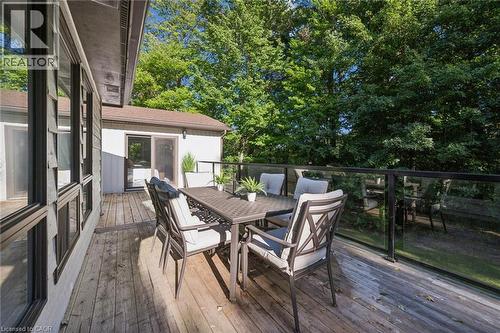 Expansive wood deck with glass panel railing and mature tree backdrop - 282 Concession Rd 2, Scotland, ON 