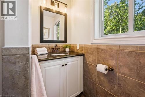White vanity with dark cabinet pulls, dark countertop, and an undermount sink - 282 Concession Rd 2, Scotland, ON 