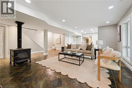 Spacious living area featuring a prominent cast iron stove, recessed lighting, and large windows - 282 Concession Rd 2, Scotland, ON 