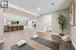 Expansive open-concept room with wood-finish flooring, recessed lighting, and a built-in bar with seating - 