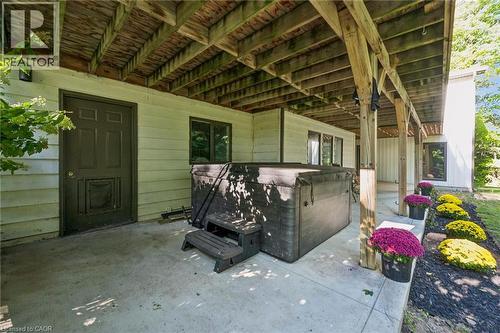 Covered patio featuring a built-in spa, concrete flooring, and multiple windows - 282 Concession Rd 2, Scotland, ON 