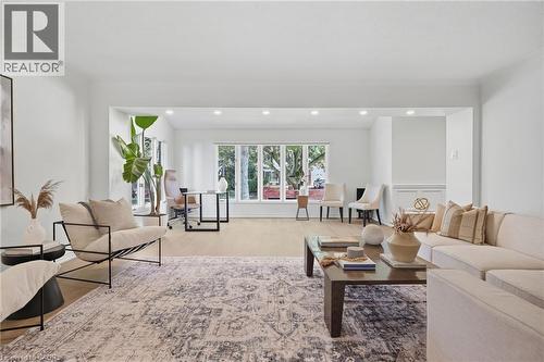 Recessed lighting, wood-finish flooring, and white walls with trim detailing define this expansive interior space - 4159 Spruce Avenue, Burlington, ON 