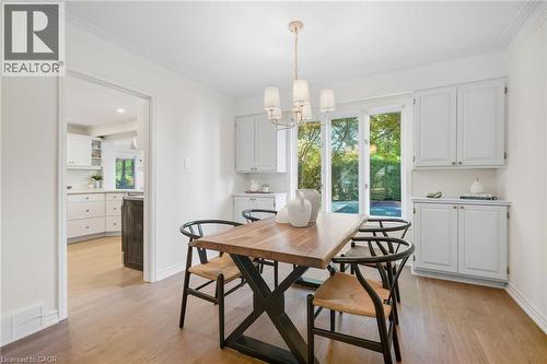 Hardwood-finish flooring, built-in cabinetry, crown molding, and a decorative chandelier - 4159 Spruce Avenue, Burlington, ON 