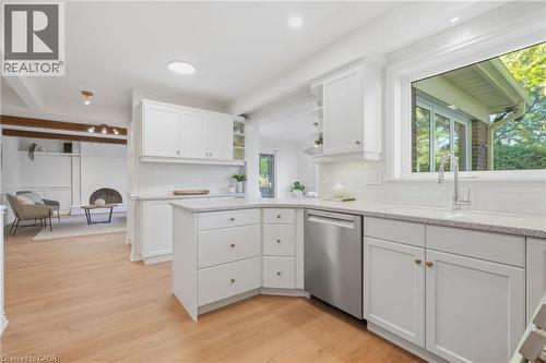 Kitchen featuring white shaker cabinetry, light-colored countertops, a stainless steel dishwasher, and a window above the sink - 4159 Spruce Avenue, Burlington, ON 