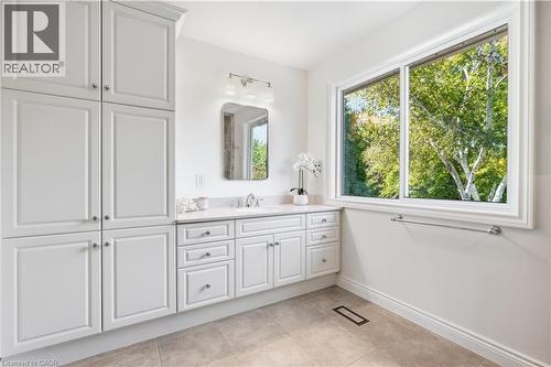 White shaker cabinetry with ample storage, a built-in vanity, and a rectangular undermount sink - 4159 Spruce Avenue, Burlington, ON 