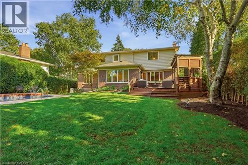 Expansive green lawn with mature trees and a multi-level wood deck - 4159 Spruce Avenue, Burlington, ON 