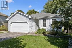 Light gray siding exterior with white trim, front porch with white railing, attached single-car garage, and established landscaping - 