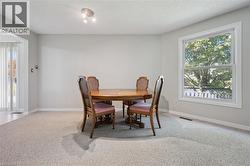 Spacious room featuring light gray walls, light gray carpet, and a large window with white trim - 