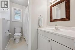 White vanity with an integrated sink and chrome faucet, set against a framed mirror with overhead lighting - 