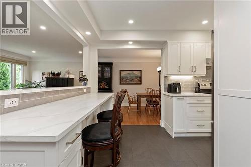 Eat-in kitchen with open concept view to family room and backyard, bonus cabinetry below peninsula, quartz counter tops - 200 Woodview Crescent, Ancaster, ON 