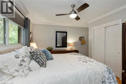 Primary bedroom with hardwood flooring, closet and view to backyard - 200 Woodview Crescent, Ancaster, ON 