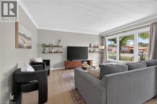 Spacious living area featuring light-toned walls, crown molding, and wood-finish flooring - 13 Allanburg Road S, St. Catharines, ON 