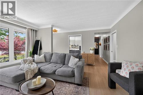 Generous living area featuring light-toned walls, wood-finish flooring, and crown molding - 13 Allanburg Road S, St. Catharines, ON 
