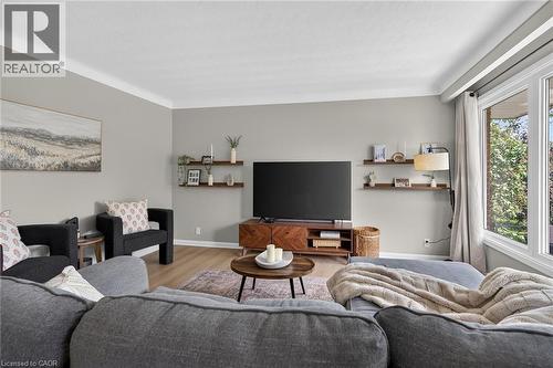 Living area featuring light gray walls with white crown molding and wood-finish flooring - 13 Allanburg Road S, St. Catharines, ON 