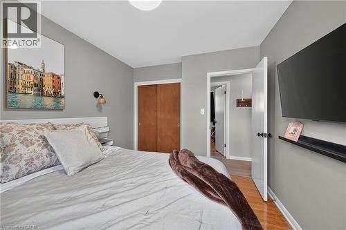 Bedroom featuring light gray walls, wood-finish flooring, and a flush-mount ceiling light - 13 Allanburg Road S, St. Catharines, ON 