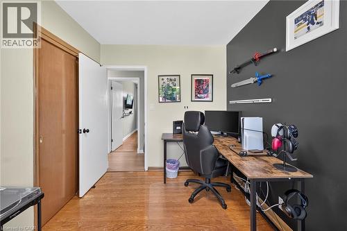 Dedicated workspace featuring wood-finish flooring and a contrasting accent wall - 13 Allanburg Road S, St. Catharines, ON 