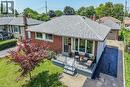 Brick facade residential property featuring a shingled roof, a front porch with wrought iron railing, a paved driveway, and a detached garage - 13 Allanburg Road S, St. Catharines, ON 