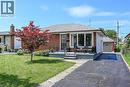 Charming brick and siding ranch home featuring a welcoming front facade with large picture windows, mature landscaping including a striking red Japanese maple, and a paved driveway leading to an attac - 13 Allanburg Road S, St. Catharines, ON 