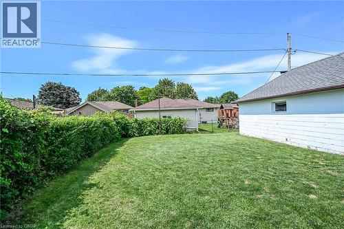 Expansive backyard featuring a manicured lawn, established privacy hedges, and a clear sky - 13 Allanburg Road S, St. Catharines, ON 