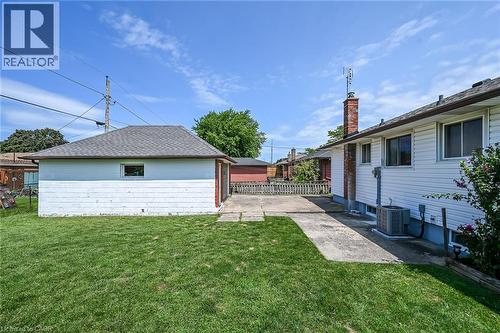 Expansive backyard featuring a detached garage with a gabled roof and a concrete driveway - 13 Allanburg Road S, St. Catharines, ON 