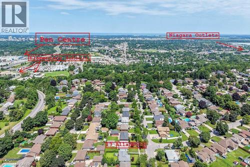 Aerial view showcasing a residential neighborhood featuring tree-lined streets, single-family homes with varied roofing, manicured lawns, and mature landscaping throughout the community - 13 Allanburg Road S, St. Catharines, ON 