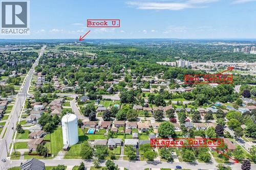 Aerial perspective showcasing this residential property nestled within an established neighborhood featuring mature tree canopy, manicured lawns, and tree-lined streets - 13 Allanburg Road S, St. Catharines, ON 