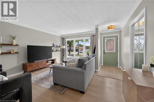 Light wood-finish flooring extending from the entryway into the living area - 13 Allanburg Road S, St. Catharines, ON 